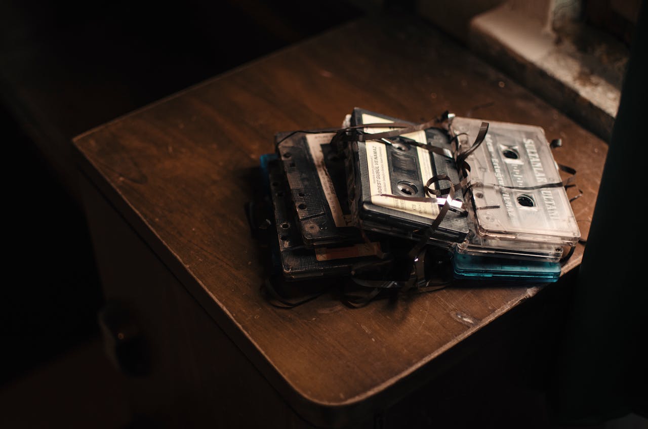 Pile of retro cassette tapes with tangled ribbons, evoking nostalgia.
